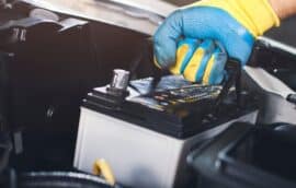 Mechanic inspecting a car battery at Ace Auto Repair in West Jordan Utah