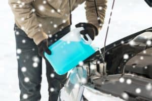 man-pouring-coolant-antifreeze-into-car