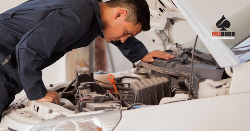 Mechanic inspecting car transmission in repair shop
