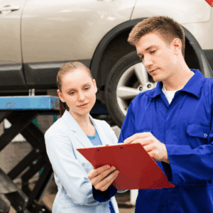 Auto technician showing customer wheel alignment angles on screen