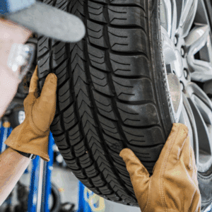 Mechanic performing wheel alignment on car using precision equipment